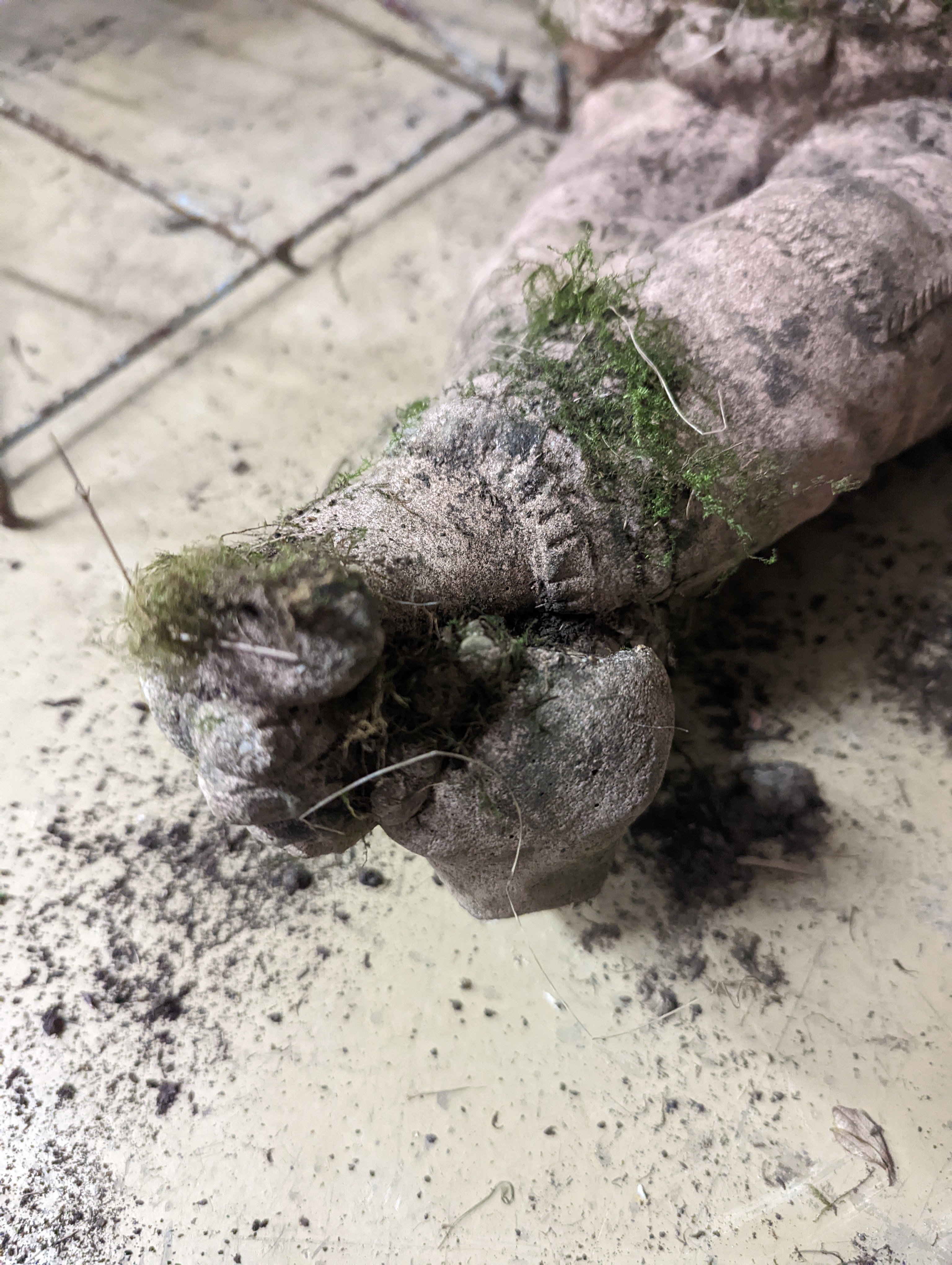 Two small circular mill stones, a reconstituted stone gargoyle and a terracotta reclining pixie garden ornament